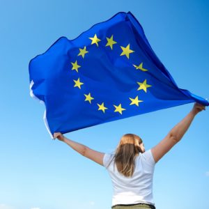 AdobeStock_286829740_Rear view of young woman waving the European Union flag