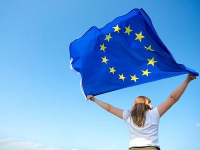 AdobeStock_286829740_Rear view of young woman waving the European Union flag