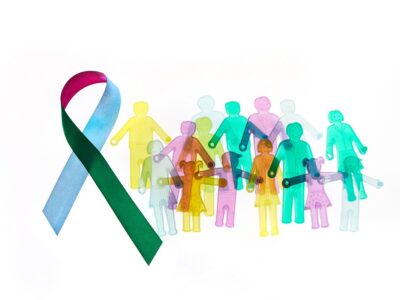 AdobeStock_482826097_Rare Disease Day Background. Colorful awareness ribbon with group of people with rare diseases.