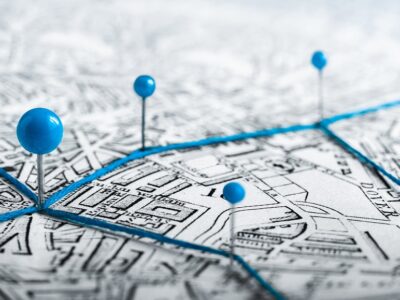 AdobeStock_357929292_Routes with blue pins on a city map. Concept on the adventure,